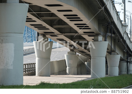 Bottom view of the concrete piers of the transport viaduct. Massive columns support the road bridge. Sunny day Bottom view of the concrete piers of the transport viaduct. Massive columns support the road bridge. Sunny day 88751902