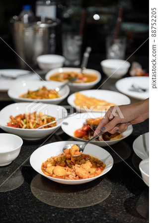 Hand using spoon scoop fried tofu and variety thai food on dining table 88752205