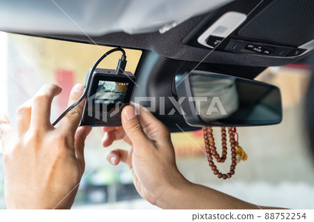 Hand of technician installing front camera car recorder on windscreen 88752254