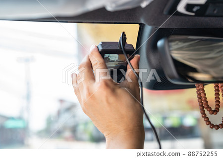 Hand of technician installing front camera car recorder on windscreen 88752255