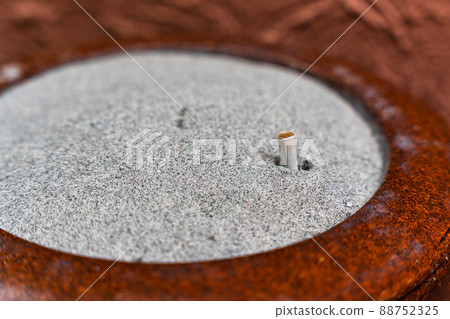 Used cigarette filter in heap sand on ashtray Used cigarette filter in heap sand on ashtray 88752325