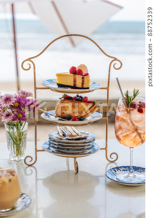 Set of cheesecake, honey toast and beverage served in cake stand on the table in cafe Set of cheesecake, honey toast and beverage served in cake stand on the table in cafe 88752339