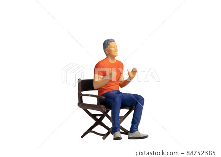 Miniature people sitting on chair isolated on white background Miniature people sitting on chair isolated on white background 88752385