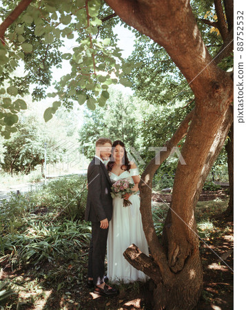 Happy wedding couple walking in a botanical park grain effect authentic Happy wedding couple walking in a botanical park grain effect authentic 88752532