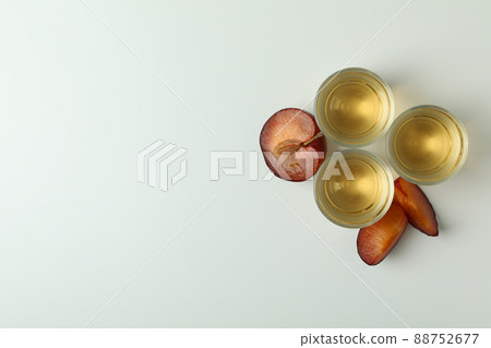 Plum vodka shots and ingredients on white background Plum vodka shots and ingredients on white background 88752677