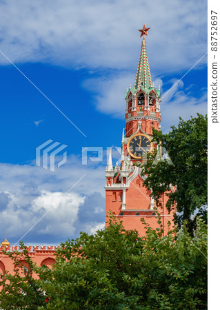 Spasskaya Tower of the Moscow Kremlin behind the green foliage of trees Spasskaya Tower of the Moscow Kremlin behind the green foliage of trees 88752697