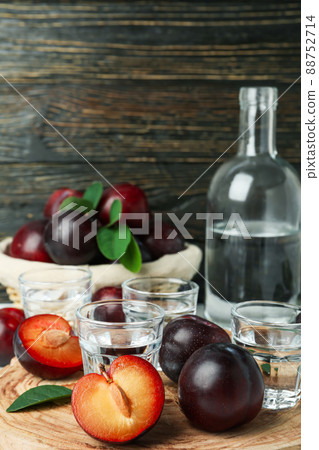 Concept of alcohol with plum vodka against wooden background Concept of alcohol with plum vodka against wooden background 88752714