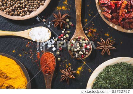 Background with variety of spices and herbs on black background top view. Cooking ingredients and condiments concept. Background with variety of spices and herbs on black background top view. Cooking ingredients and condiments concept. 88752737