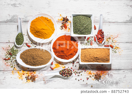 Various spices in a bowls on white wooden background. Top view with copy space. Cooking ingredients and condiments concept. 88752743
