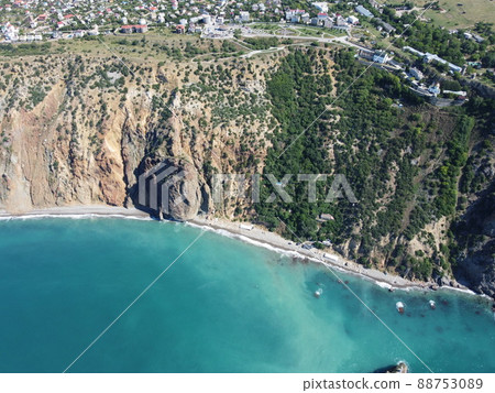 Aerial view from above on calm azure sea and volcanic rocky shores. Small waves on water surface in motion blur. Nature summer ocean sea beach background. Nobody. Holiday, vacation and travel concept 88753089