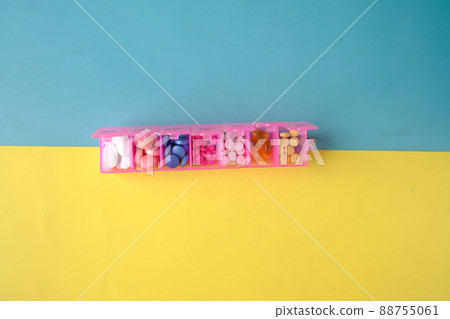 top view of medical pills in a pill box on color background  88755061