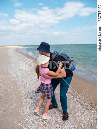 Happy family father daughter hugging on marine landscape. Bearded dad with child in hands having fun together Happy family father daughter hugging on marine landscape. Bearded dad with child in hands having fun together 88755432