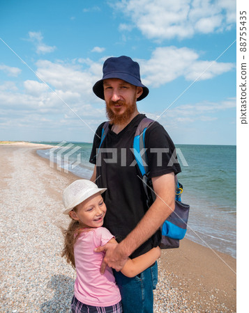 Happy family father daughter hugging on marine landscape. Bearded dad with child in hands having fun together 88755435