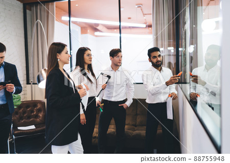 Group of diverse coworkers talking about business strategy Group of diverse coworkers talking about business strategy 88755948