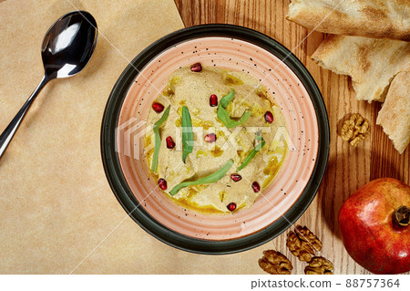Chicken satsivi in walnut sauce garnished with greens and pomegranate seeds Chicken satsivi in walnut sauce garnished with greens and pomegranate seeds 88757364