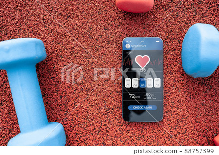 Gym application. Smart phone screen with fitness health or sport gym mobile application on dumbbell background. Online fitness program. 88757399