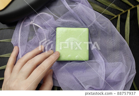 Solid hair shampoo. Composition of golden curls, soap suds, solid shampoo and comb. The concept of female care for long hair. Solid hair shampoo. Composition of golden curls, soap suds, solid shampoo and comb. The concept of female care for long hair. 88757937