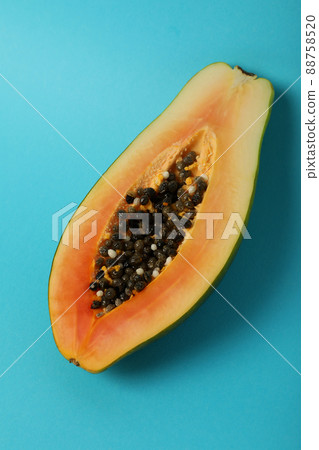 Half of ripe papaya on blue background Half of ripe papaya on blue background 88758520