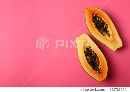 Halves of ripe papaya on pink background 88758521