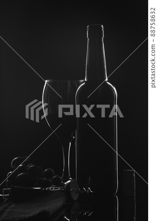 Silhouette of a wine bottle, a wine glass and grapes on black background. 88758632