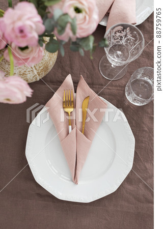 Elegant pink linen napkin on the brown tablecloth 88759765
