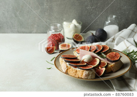 Concept of tasty food with bruschetta with fig on white textured table Concept of tasty food with bruschetta with fig on white textured table 88760083