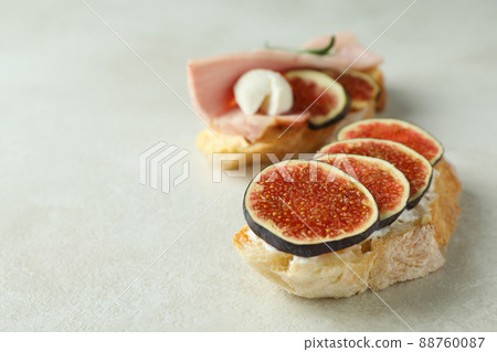 Tasty bruschetta with fig on white textured background Tasty bruschetta with fig on white textured background 88760087
