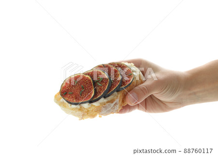 Female hand holds bruschetta with fig, isolated on white background Female hand holds bruschetta with fig, isolated on white background 88760117