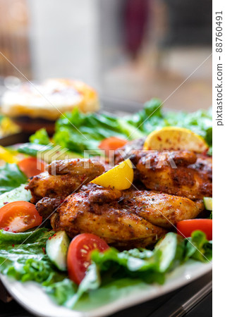 Tobacco chicken with lettuce, lemon and tomato... - Stock Photo [88760491] 