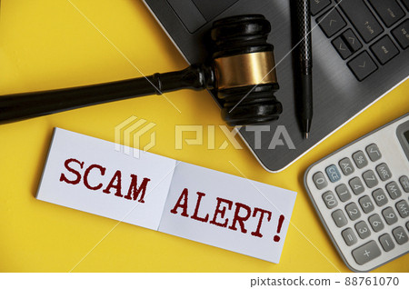 Scam alert text on notepad with gavel, laptop, pen and calculator background. Security concept Scam alert text on notepad with gavel, laptop, pen and calculator background. Security concept 88761070
