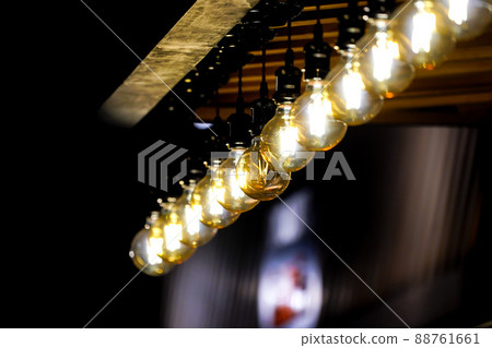 Tungsten circle lamp light on the row, stick on the wood kiosk ceiling. 88761661