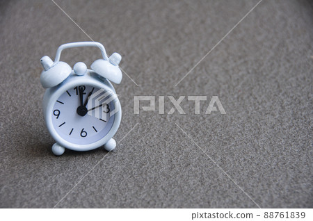 White alarm clock isolated on marble floor The clock set at 1 o'clock. 88761839