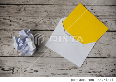 Top view of empty envelope with crumpled paper and wooden table background. Copy space concept 88761841