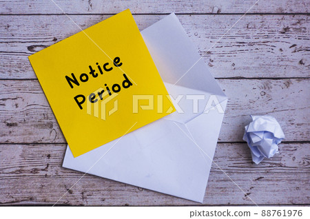 Notice period text on yellow notepad with envelope background. 88761976