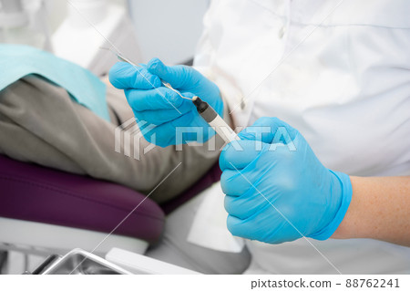 Composite filling material used in dentistry. Dentist's hands in sterile gloves close-up. 88762241