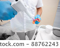 Dentist prepares material for a mold of teeth. Close-up of a dentist in blue gloves 88762243