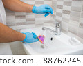 The dentist rinses the dental impression with water under pressure. Close-up of dentist's hands in blue gloves 88762245