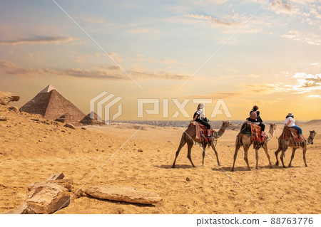 European tourists riding camels near the Pyramids of Egypt 88763776