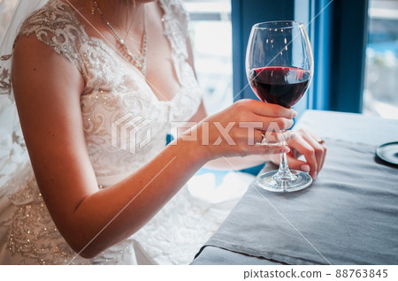 Glass with wred wine in the girls hand 88763845