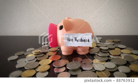 Saving money into piggy bank for hire purchase payment. Money concept. Saving money into piggy bank for hire purchase payment. Money concept. 88763912