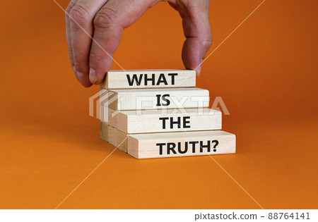 What is the truth symbol. Concept words 'What is the truth' on wooden blocks on a beautiful orange background. Businessman hand. Business, what is the truth concept. What is the truth symbol. Concept words 'What is the truth' on wooden blocks on a beautiful orange background. Businessman hand. Business, what is the truth concept. 88764141