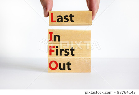 LIFO last in first out symbol. Concept words LIFO last in first out on wooden blocks. Beautiful white table white background. Businessman hand. Business and LIFO last in first out concept. Copy space. 88764142