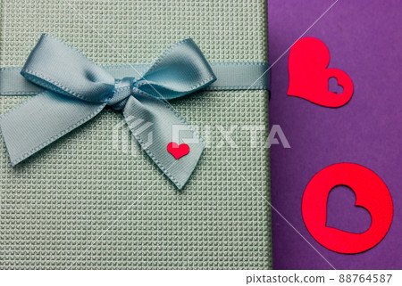 Blue gift box, bow, little red heart. Confetti hearts on purple. Valentine's Day Blue gift box, bow, little red heart. Confetti hearts on purple. Valentine's Day 88764587
