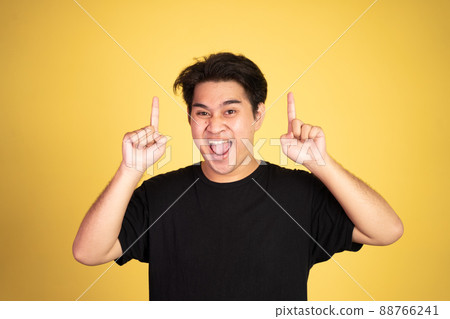 excited young man with two fingers pointing up excited young man with two fingers pointing up 88766241