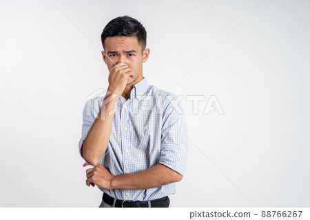 man cover his nose and feeling disgusted by the smell man cover his nose and feeling disgusted by the smell 88766267
