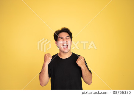 excited asian man with two hands clenched 88766380