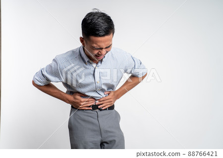 man having stomachache holding his stomach with two hands 88766421