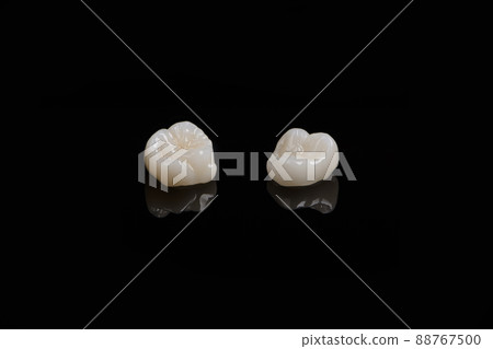 Qualified anatomic ceramic and zirconia crowns of human teeth close up macro isolated on black background. Qualified anatomic ceramic and zirconia crowns of human teeth close up macro isolated on black background. 88767500