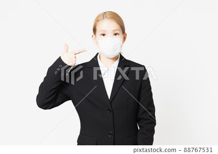 一個年輕女子指著夾克里的面具 88767531