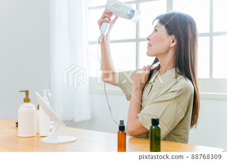 使用吹風機的中年婦女（微笑） 88768309